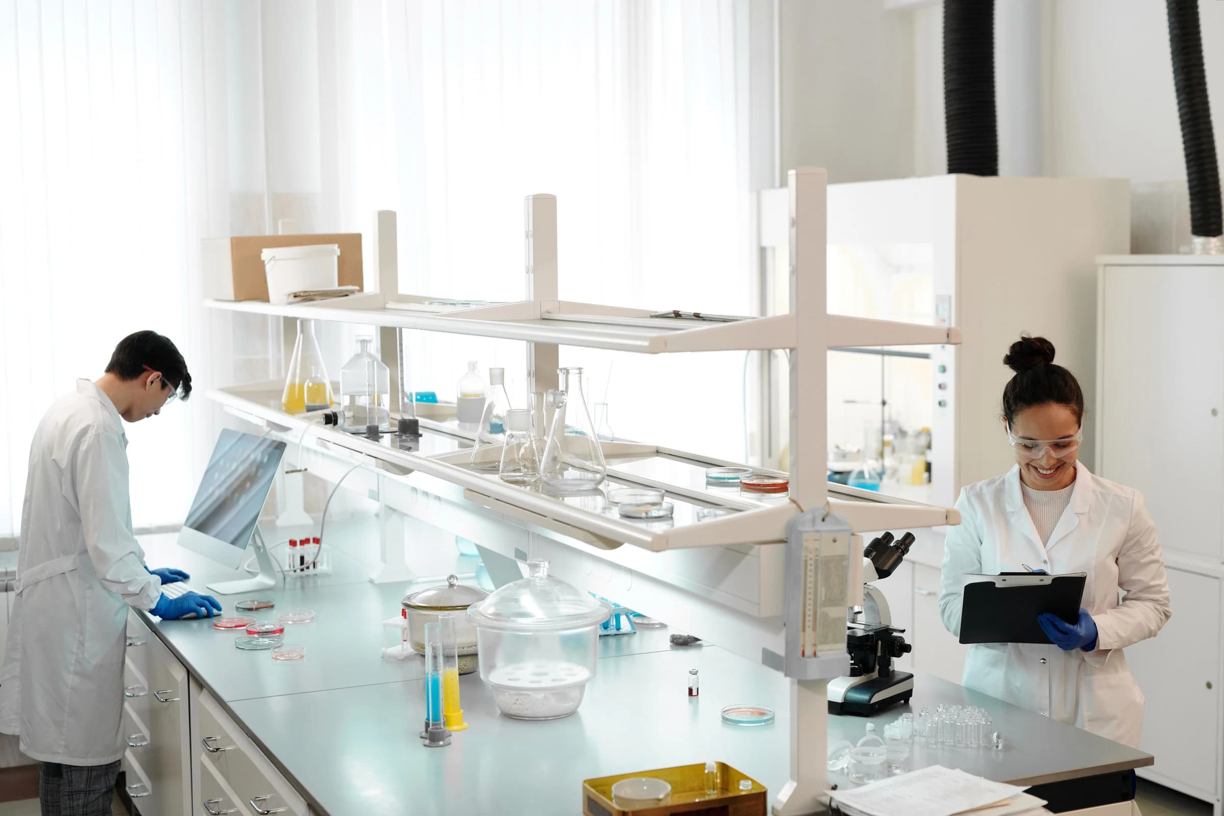 Two researchers in a laboratory equipped with glassware and instruments